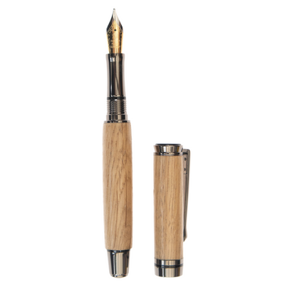 Image of The Tower of London handcrafted wood fountain pen made by Wig and Pens. The body of the pen is made from Old English oak with gunmetal grey nib, tip and clip. This is a fountain pen but there is a ballpoint option available. Images shows pen with lid off.